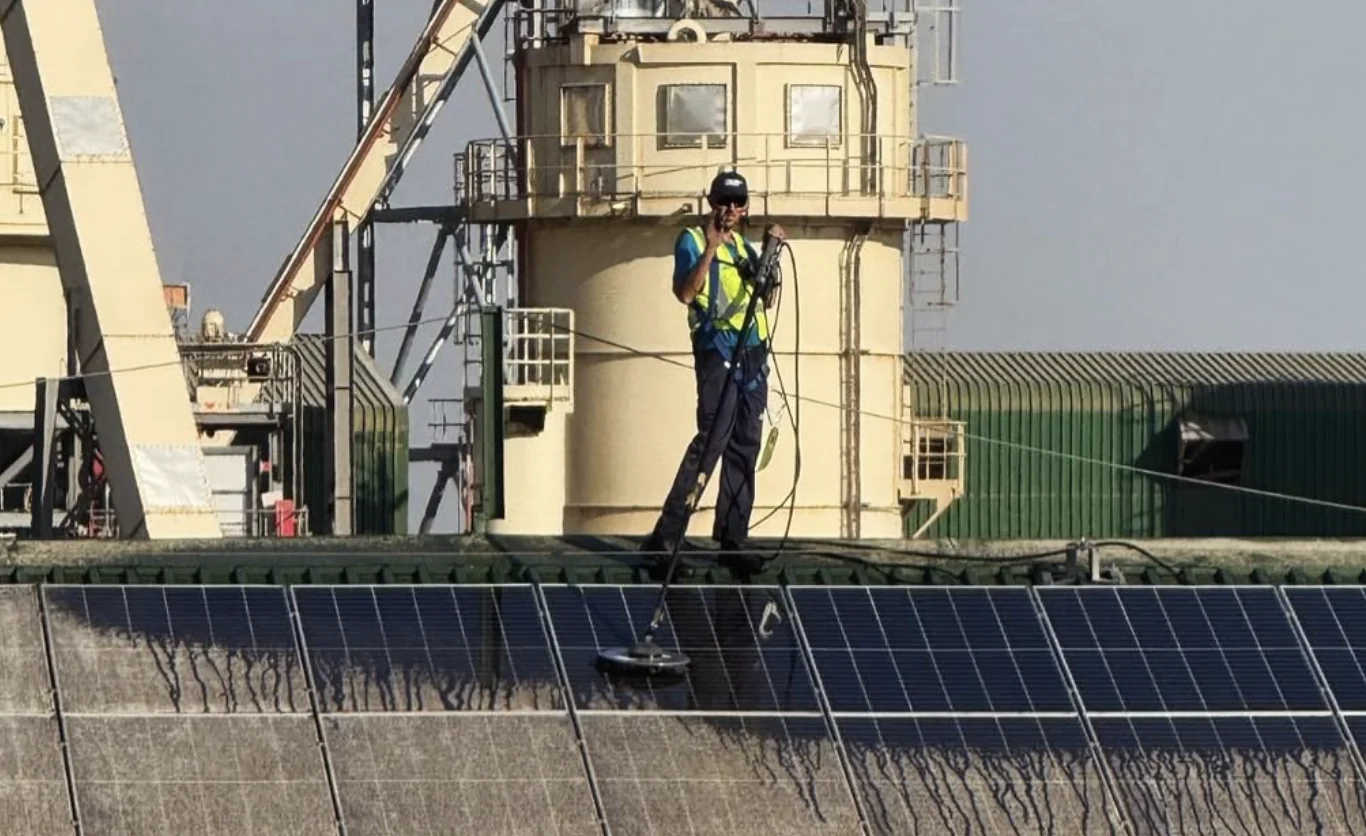 Technician cleaning solar panels at PG Bison Piet Retief