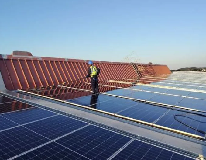 Technician cleaning rooftop solar panels at Yanfeng Port Elizabeth